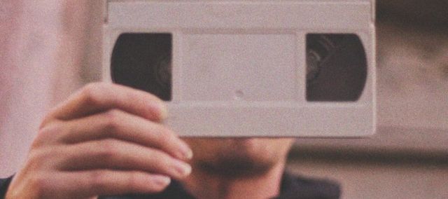 Man holding a white VHS tape